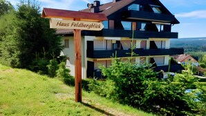 A two-story house with a sign reading 'Haus Feldbergblick' in front.