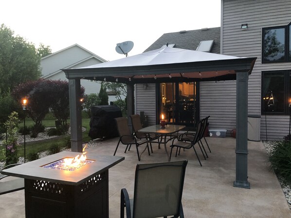 Relax in the shaded patio area, complete with a fire feature and comfortable seating for dining or socializing.