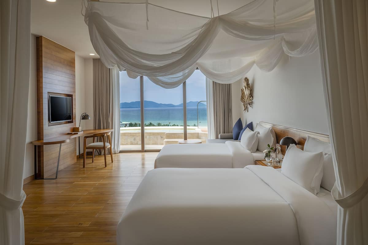 A hotel room with a large bed, a desk, and a TV.