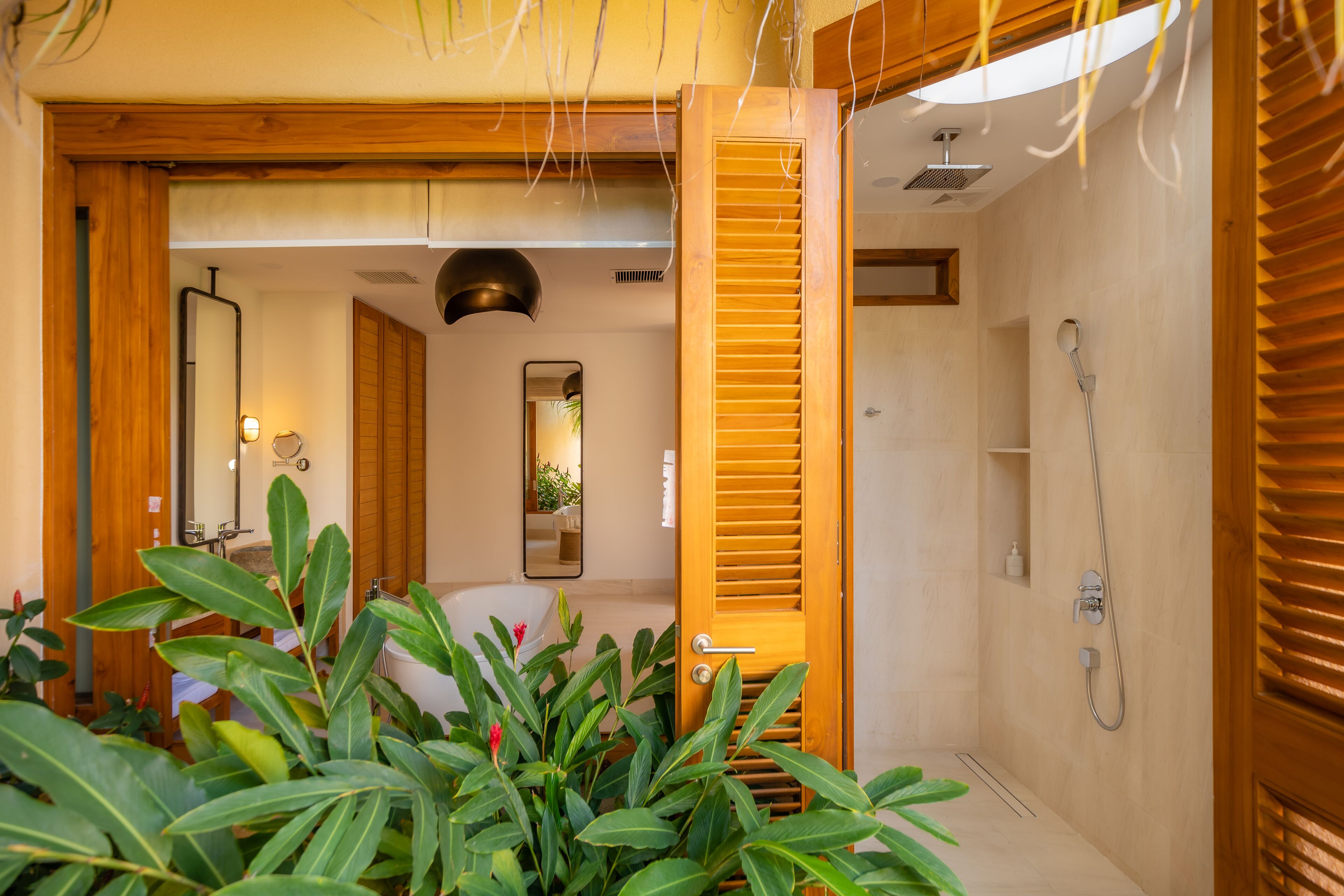 A bathroom with a shower, a mirror, and wooden doors.