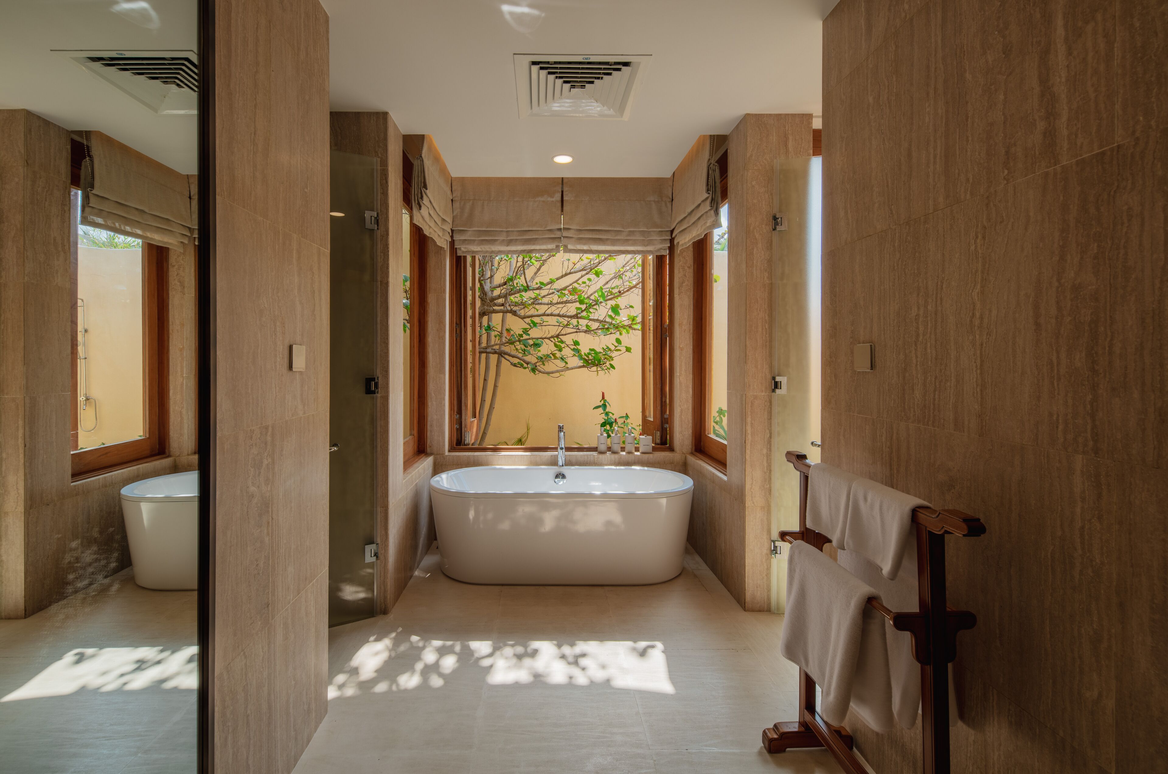 Ein modernes Badezimmer mit einer freistehenden Badewanne, einer Toilette und einem Handtuchhalter.