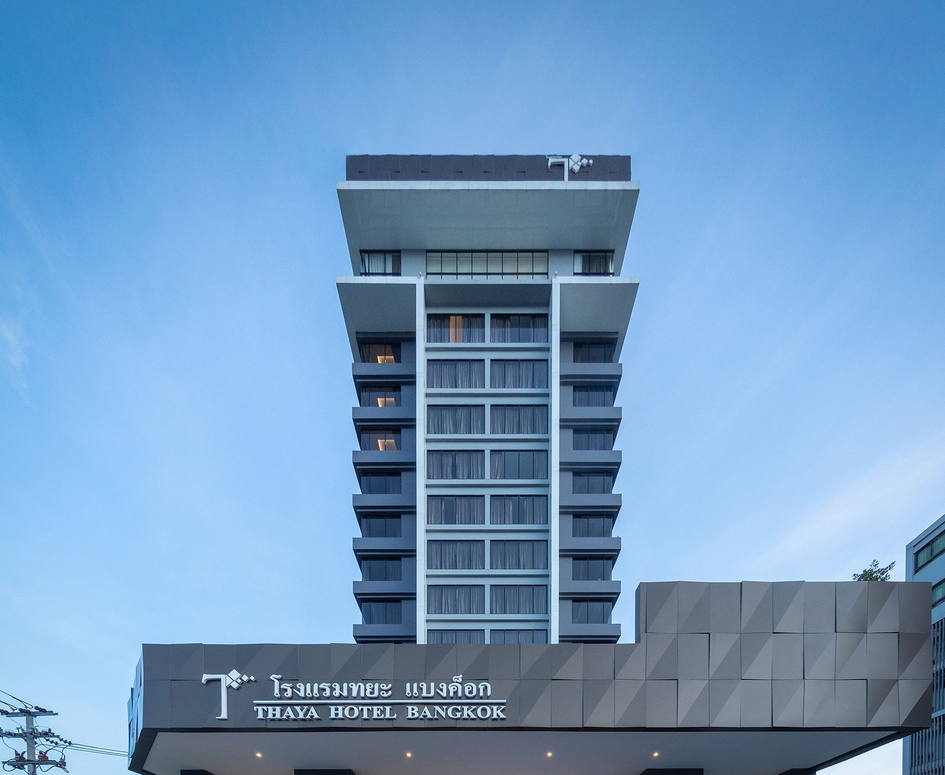 Moderni hotellirakennus, jonka julkisivussa on selkeästi näkyvä Thaya Hotel Bangkok -kyltti.