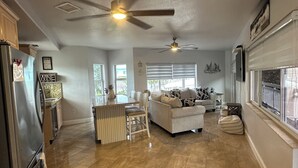A spacious living area with a kitchen, dining area, and a large window providing natural light. - Key largo home (Key Largo)