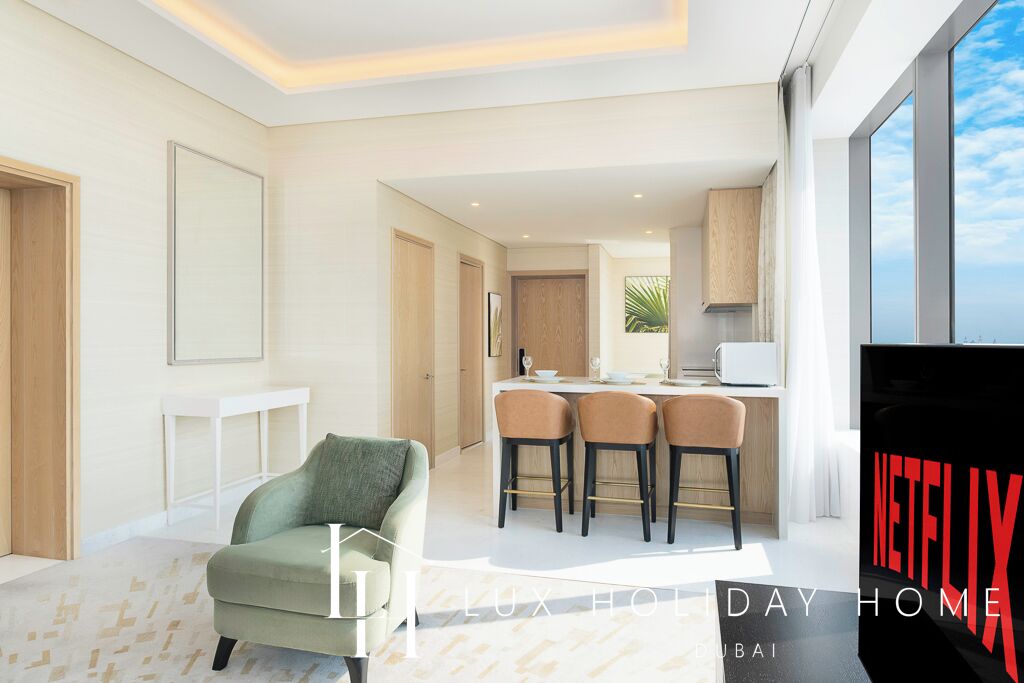 Un salon moderne avec un canapé, un coin repas avec des chaises et une cuisine en arrière-plan.