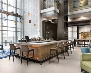 Relax in our stylish lobby, featuring a central bar with a long countertop and comfortable seating areas.