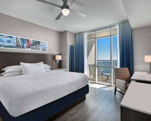 Relax in comfort with a large bed, ceiling fan, and desk with chair.