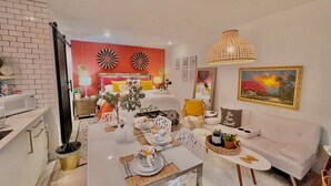 A modern living room with a dining area, a sofa, and a dining table set for four. - Modern Bohemian Studio - in Golf neighborhood - Disney 15 min (Davenport)