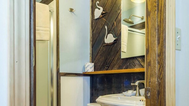 Un baño pequeño con inodoro, lavamanos y ducha.