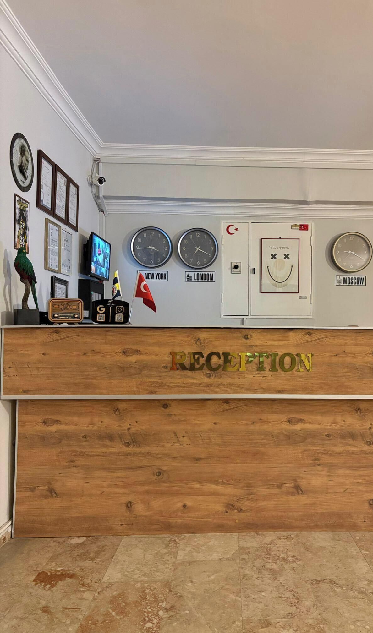 A reception desk with clocks displaying New York, London, and Moscow times, a flag, and a sign that says "RECEPTION".