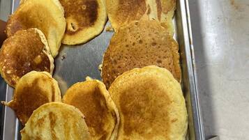 A tray of pancakes on a stainless steel surface.