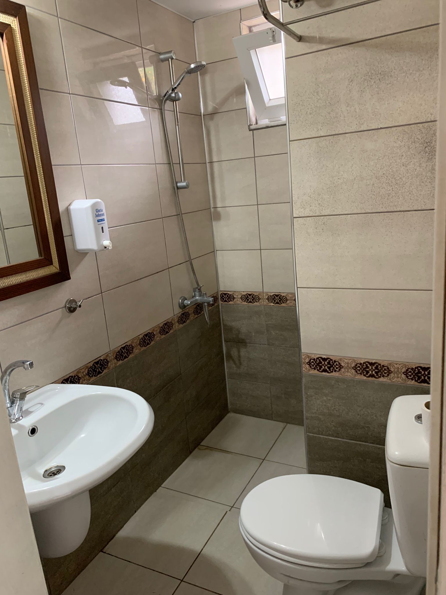 A bathroom with a sink, toilet, and shower.