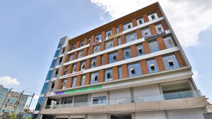 Un immeuble à plusieurs étages, sur lequel on peut lire les enseignes suivantes : « Hôtel Newborn », « Centre de soins pour nouveau-nés Apple », « Hôpital Vedanta Orthopédique et Honeys » et « Naksh Yoga ».