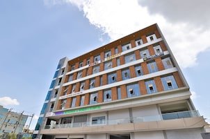 A multi-story building with signs for "Hotel Newborn," "Apple Newborn Care Centre," "Vedanta Orthopaedic & Honeys Hospital," and "Naksh Yoga."