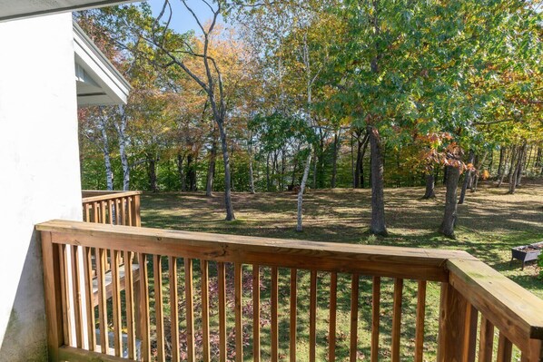 Une terrasse en bois offrant une vue sur une zone boisée.