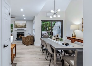 A modern interior with a dining area, fireplace, and a view of the outdoors.