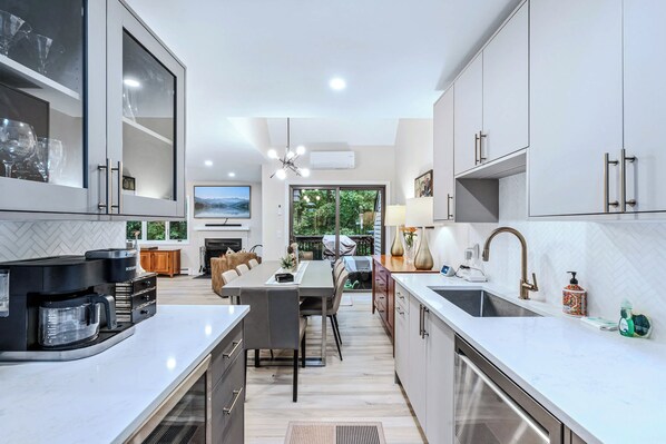 A modern kitchen with a central island, built-in appliances, and a view to the outdoors.