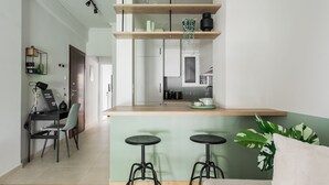 A modern kitchen with wooden shelves, a coffee machine, and a green plant.