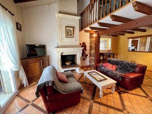 A living room with a fireplace, a sofa, a television, and a staircase. - House a few steps from the beach G0108 (Hourtin)