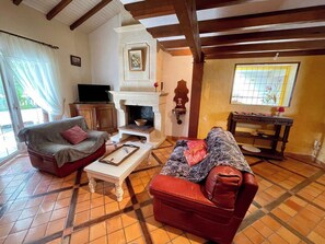 A living room with a fireplace, two sofas, a coffee table, and a television. - House a few steps from the beach G0108 (Hourtin)