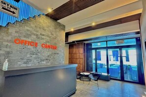 Ein Empfangsbereich mit modernem Design, eine Sky Bar Beschilderung darüber und ein Blick nach draußen durch große Glaswände.
