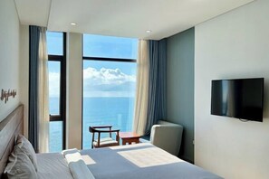 Une chambre d’hôtel avec un lit, une télévision, une petite table et une chaise.