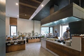 A modern kitchen with chefs at work, equipped with stainless steel appliances and ample counter space. - Joy Trip Hotel & Spa Nha Trang (Nha Trang)