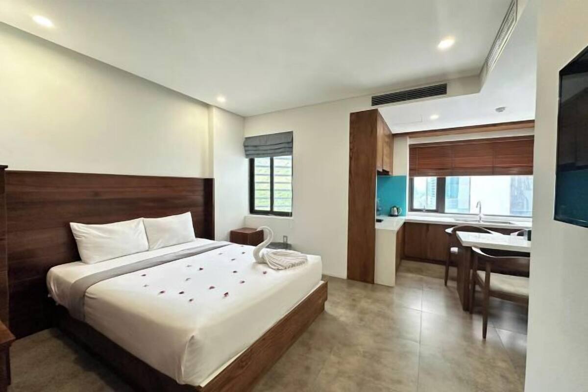 Une chambre d’hôtel avec un lit, un bureau et une chaise.
