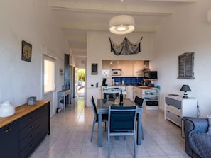 A spacious kitchen with modern appliances, a dining area with a table and chairs, and a cozy seating area with a bed.