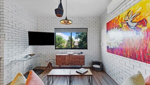 A modern kitchen with white brick walls, a wooden cabinet, a glass shelf, and a large window. - Fi's Beach Pad (Port Macquarie)