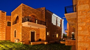 A stone building with a balcony and a door. - Independed Stone villa common pool (Παλαιλώνι)