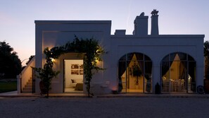 A modern building with a flat roof, a staircase leading to the entrance, and a large arched doorway.