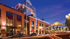 A multi-story hotel with a prominent sign, a curved road with light trails, and a decorative archway. - Hard Rock Hotel SAN Diego (SAN DIEGO)