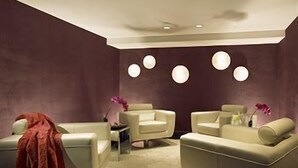 A modern room with two sofas, a small table, and a decorative wall with circular lights. - Hard Rock Hotel SAN Diego (SAN DIEGO)