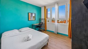 A hotel room with a bed, a desk, a chair, and a window with curtains. - Chic apart with parking (Mantes-la-Jolie)