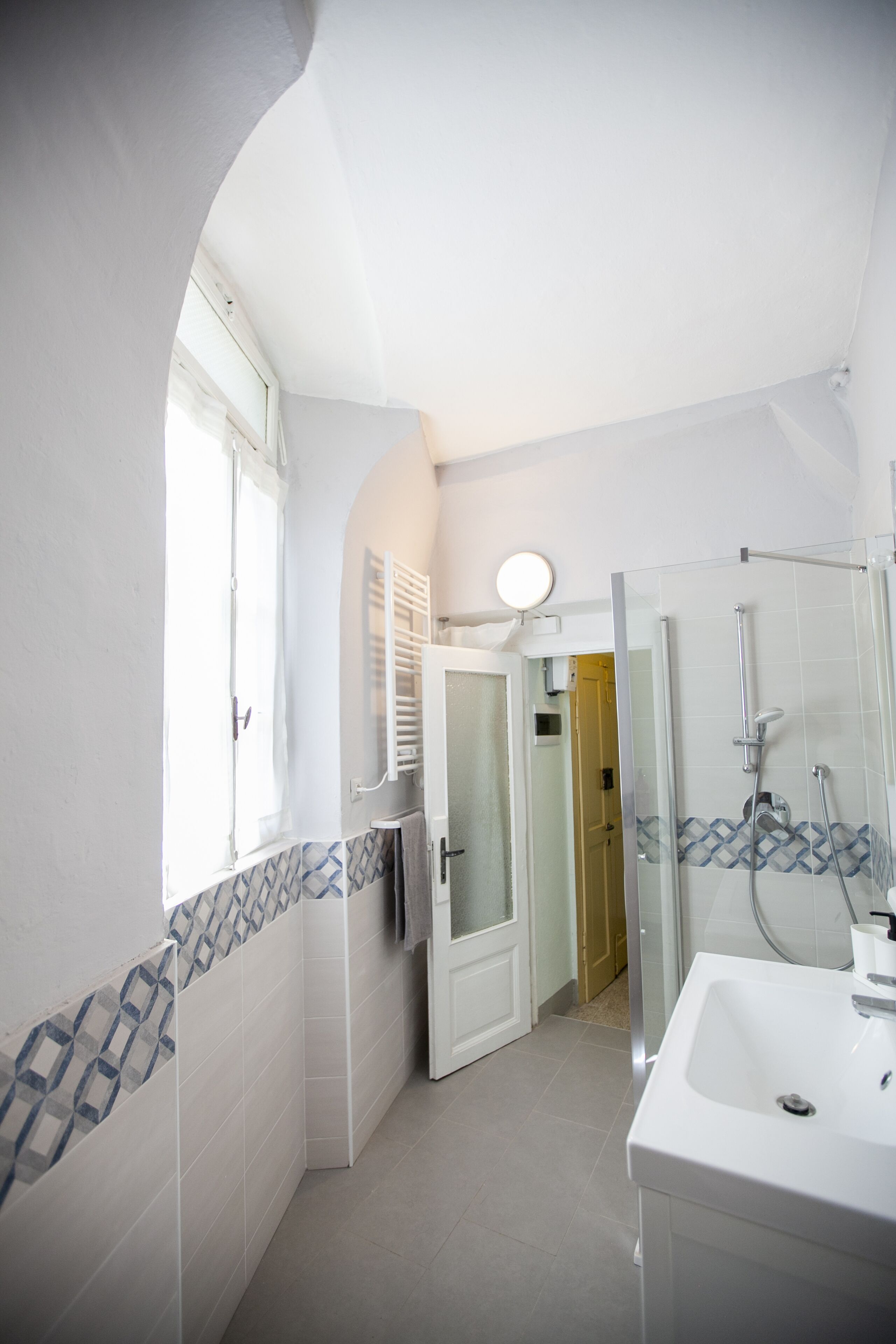 A modern bathroom with a shower, a sink, and a mirror.