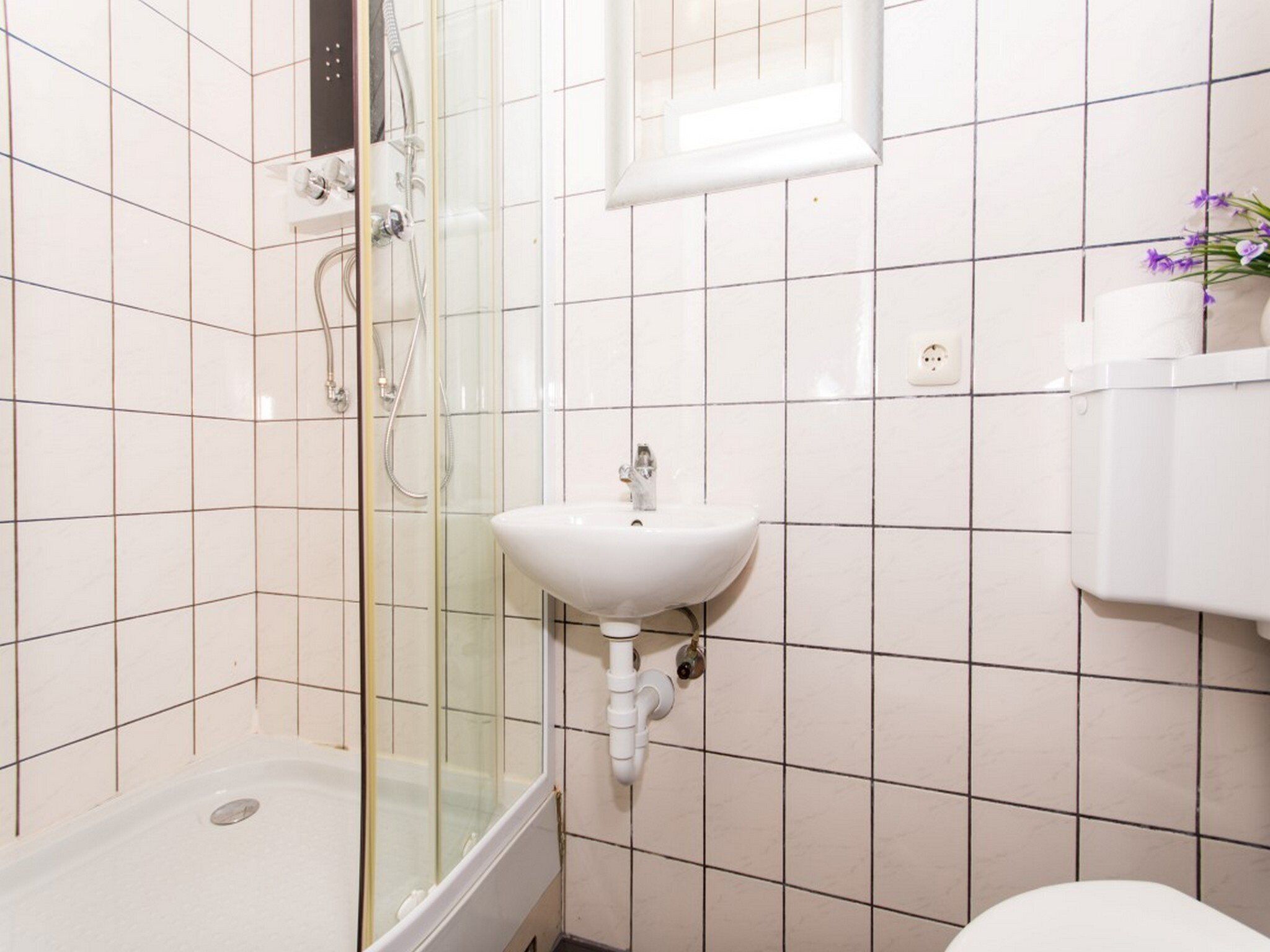 A bathroom with a shower, a sink, and a toilet.