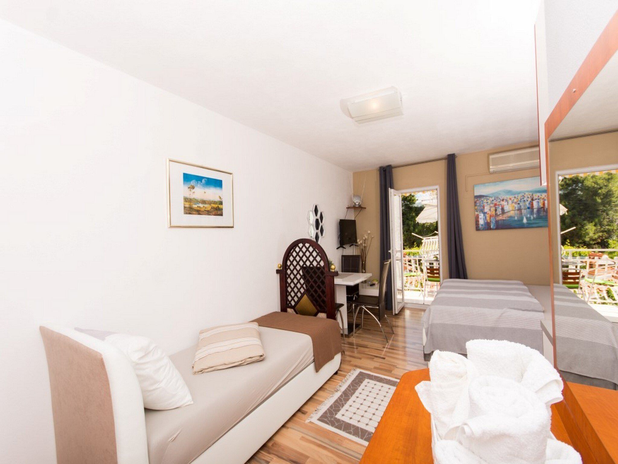 Ein Hotelzimmer mit Sofa, Bett, Schreibtisch und Blick ins Freie.