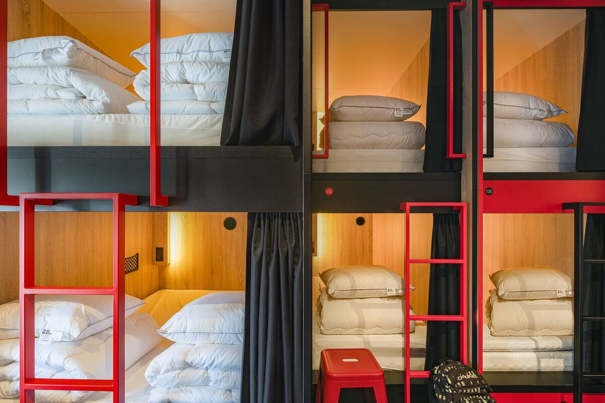 A multi-level bunk bed room with wooden paneling and red accents.