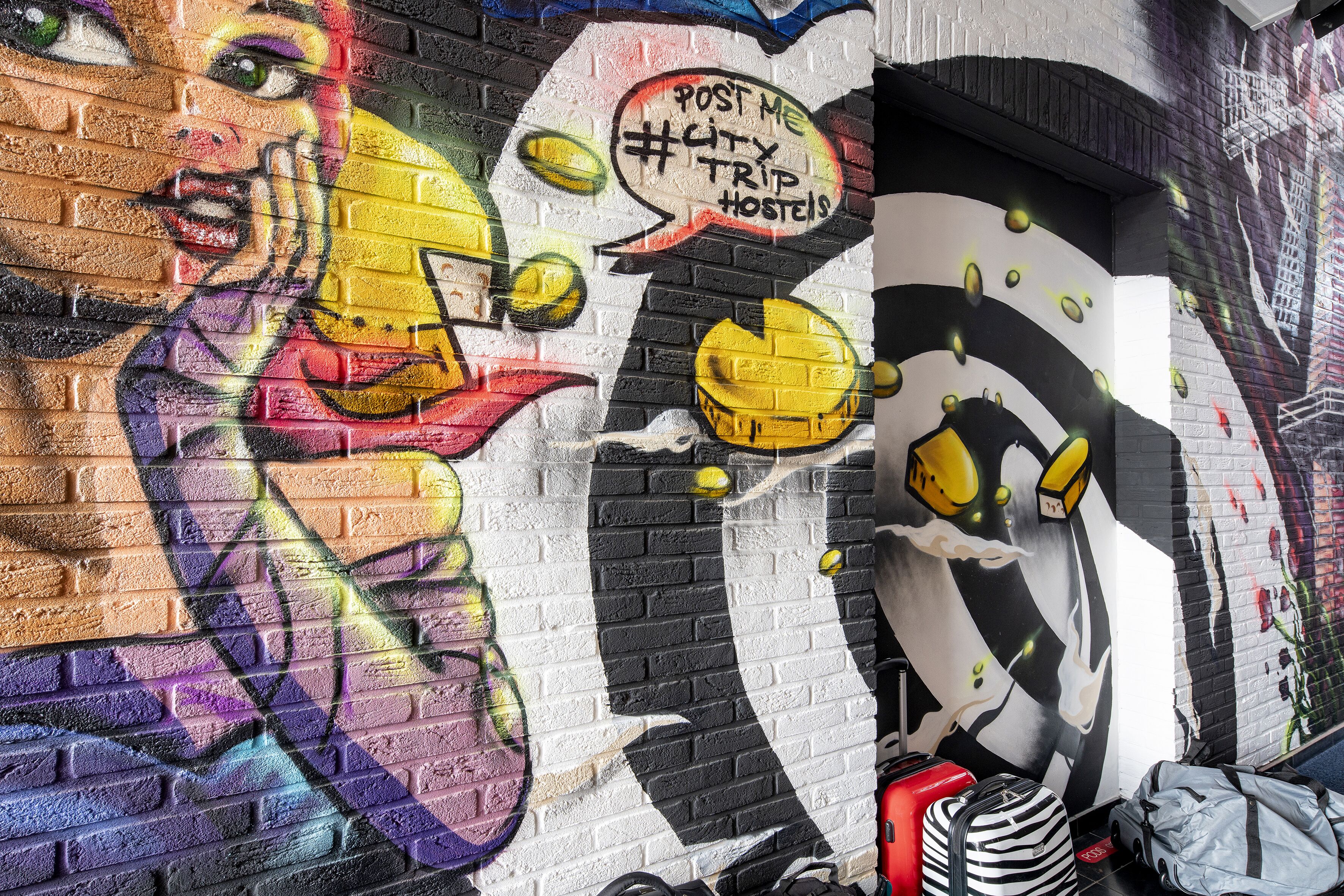 Een muur met graffiti, waaronder een gezicht en een spraakballon met tekst.