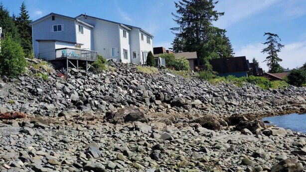 A coastal house with a rocky shoreline, a small deck, and a view of the sea. - {Forget-Me-Not Inn} Alaskan Vacation Rental (Bear Suite) (Sitka)