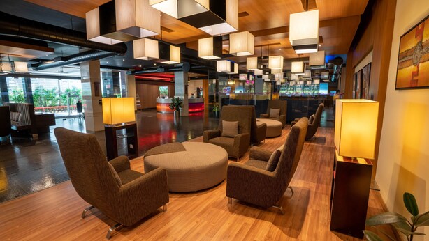 A modern lobby with wooden flooring, contemporary furniture, and pendant lighting. - Hotel Halez (Chennai)