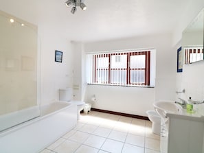 A modern bathroom with a bathtub, toilet, and sink. - The Corn Tallet (Bideford)