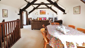 A cozy dining area with a wooden table, chairs, and a colorful tablecloth. - The Corn Tallet (Bideford)