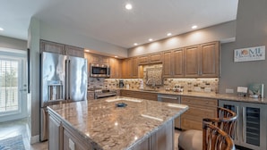 A modern kitchen with granite countertops, stainless steel appliances, and wooden cabinetry. - 3 Bedroom villa with panoramic Gulf view and sleeps 8, C1824A* (Englewood)