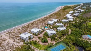 An aerial view of a coastal resort with beachfront villas, a tennis court, and a pool area. - 3 Bedroom villa with panoramic Gulf view and sleeps 8, C1824A* (Englewood)