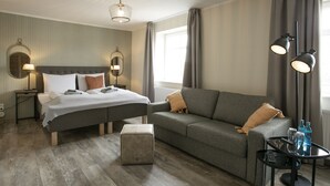 A hotel room with a bed, a sofa, a small table, and a lamp. - Himmelreich Braunfels (Braunfels)