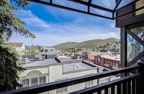 A view from a balcony with a clear sky, overlooking a town with buildings and a hill in the distance. - Treasure Mountain Inn - Main Street Condo - Top Floor (Park City)