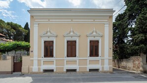 A building with three windows, a door, and a small porch area.