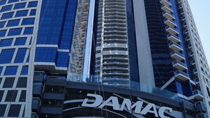 A high-rise building with a prominent 'DAMAC' sign at the base. - Luxury 2BR Apartment in Paramount Towers Business Bay (Dubai)