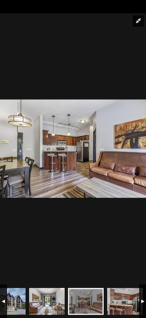 Enjoy a fully equipped kitchen with stainless steel appliances, a dining area, and a cozy seating space.